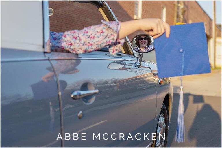 High school senior hanging his cap out the window of a vintage car