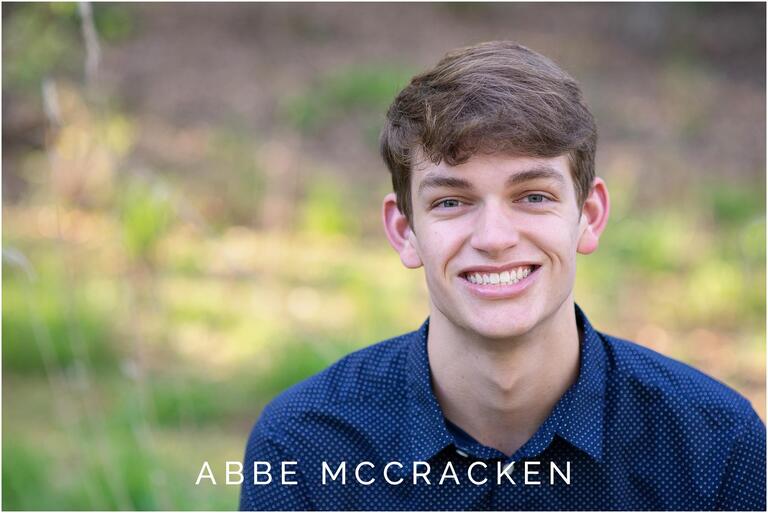 Portrait of a high school senior guy in a blue button up
