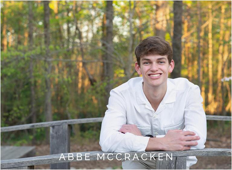 Senior portrait of a boy in a white button down shirt and khaki pants