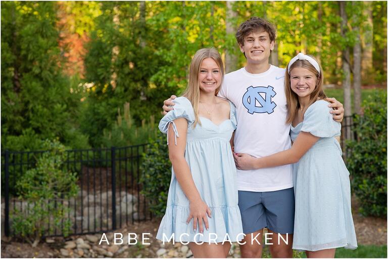 Portrait of a high school senior son with his two younger sisters