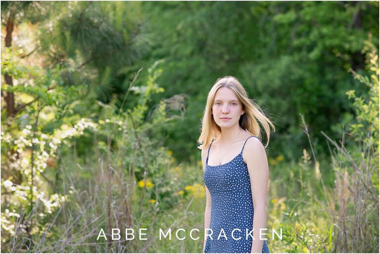 Natural portrait of a high school senior at Marvin Efird Park, spring portrait with yellow flowers in the field