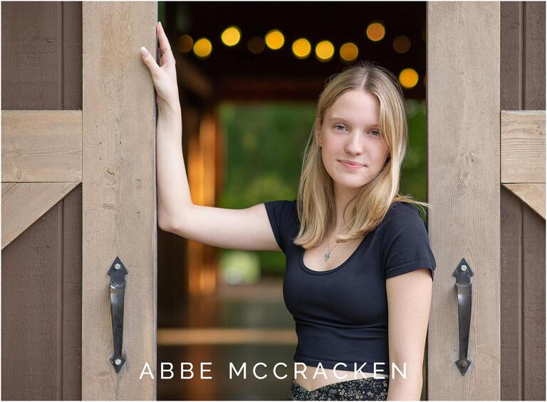 Senior portrait at a barn with fairy lights