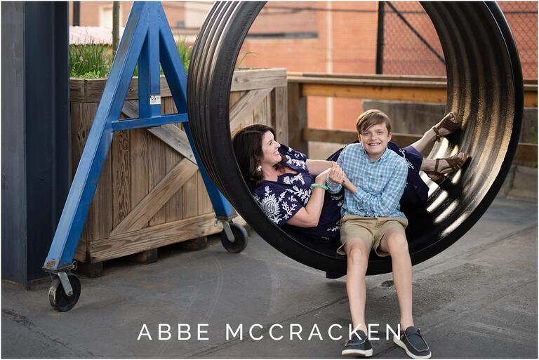 Candid image of mother and son sitting in the swings at Camp North End