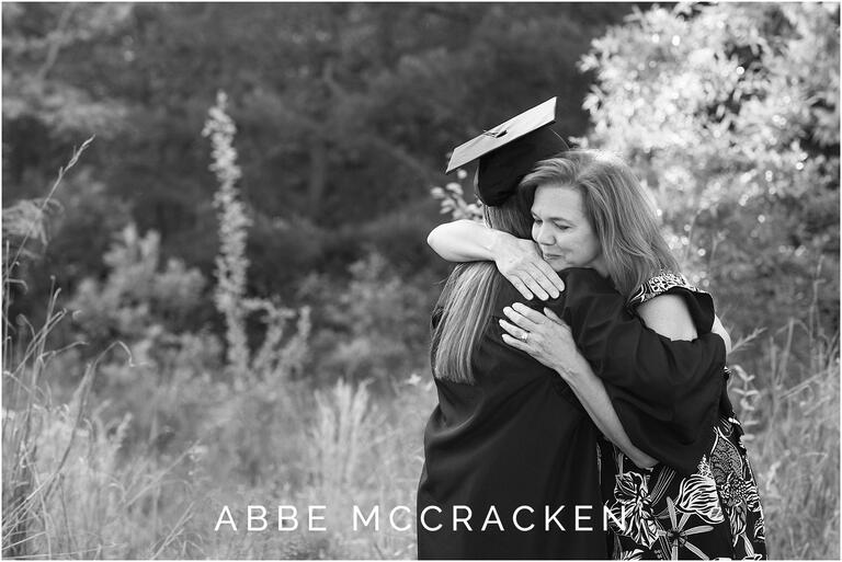 black and white portrait of mom hugging daughter who is wearing graduation cap and gown