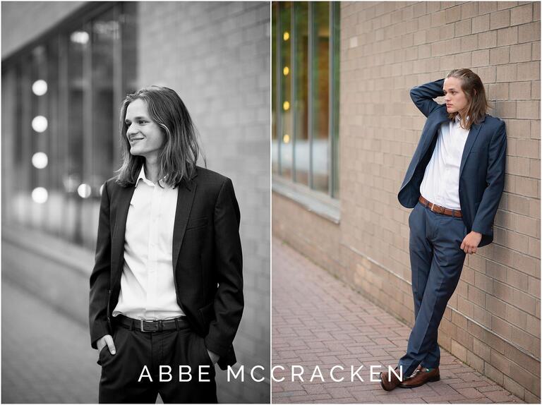 Senior portraits in Uptown Charlotte, senior guy in blue suit leaning on side of the Knight Theater