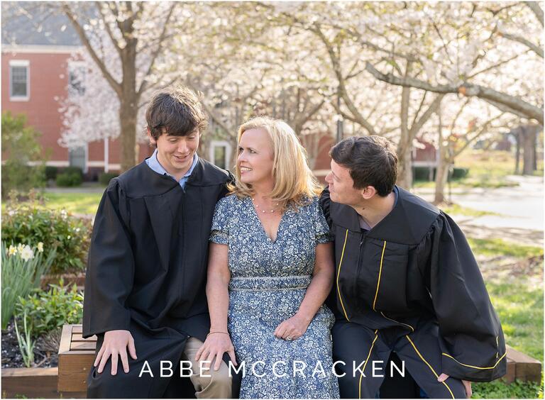 Grads wear cap and gowns at senior portrait session, mother and sons