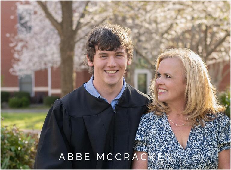 Mother and son smile in front of spring trees
