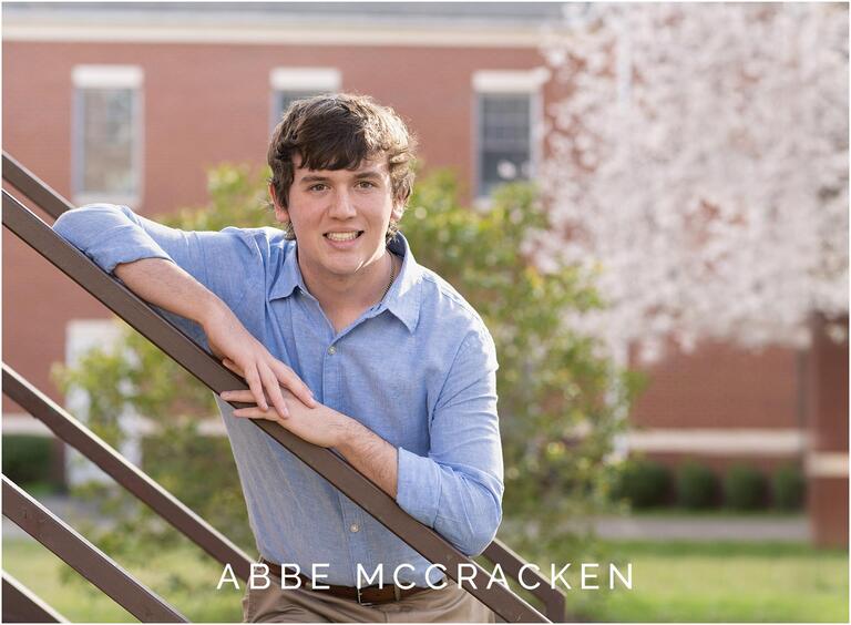 Teen boy poses on stairs in Matthews, NC at senior photo session