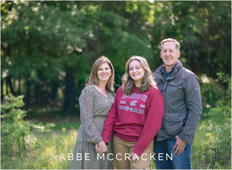 Family posing in tall grass at senior portrait session