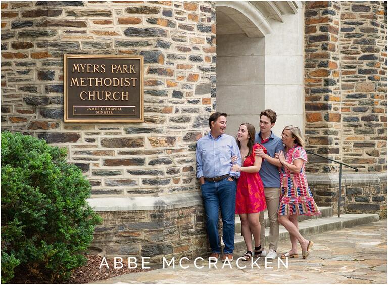 Family of four stands outside of Myers Park Methodist Church, senior session, pink