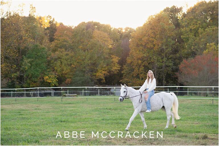 Senior pictures of blonde girl riding her white horse