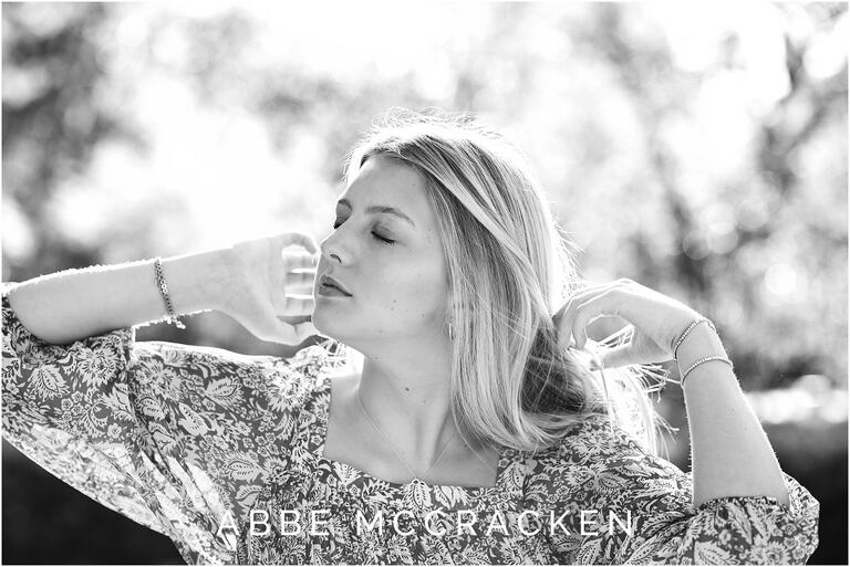 Black and white backlit senior portrait with eyes closed