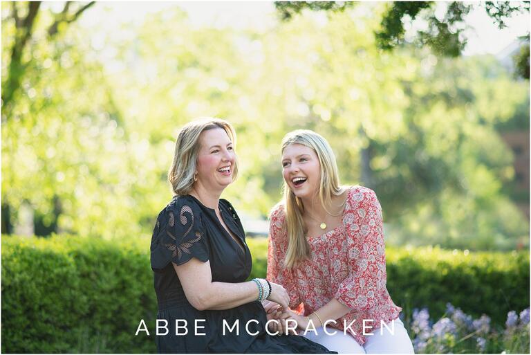 Mother and daughter laughing, photographed during a senior portrait session with high school senior