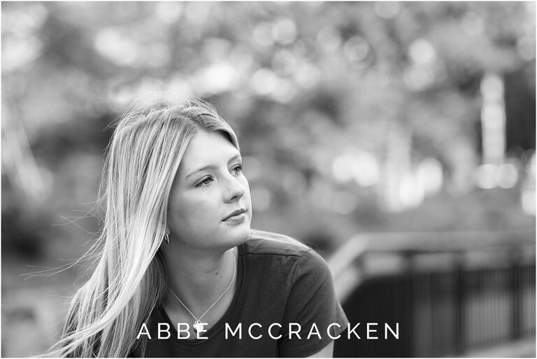 Black and white image of a blond high school senior looking camera right reflectively
