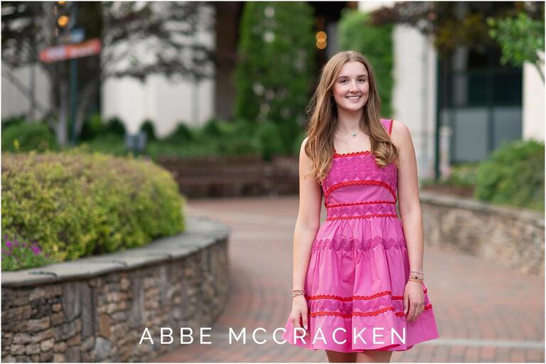 Uptown Charlotte senior portrait of a girl in pink dress, photographed on The Green