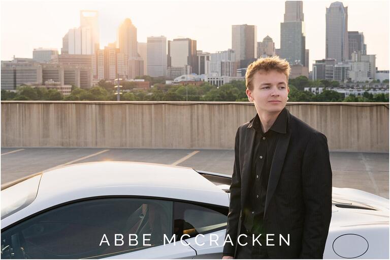 High school senior portrait with sun setting over Uptown Charlotte