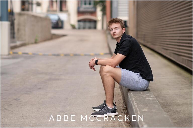 Picture of a high school senior sitting in an alley