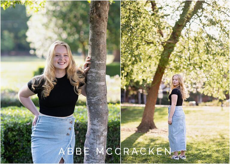Portraits of a high school senior in casual black t shirt, jean skirt and adidas shoes, bokeh in the background as light comes through the trees