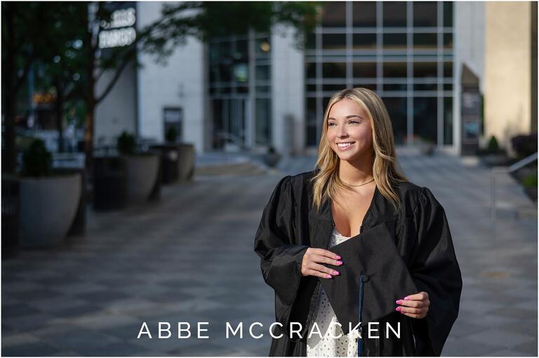 Senior portrait of a girl in cap and gown near the Mint Museum in Charlotte, NC; Gorgeous sunset reflecting onto her