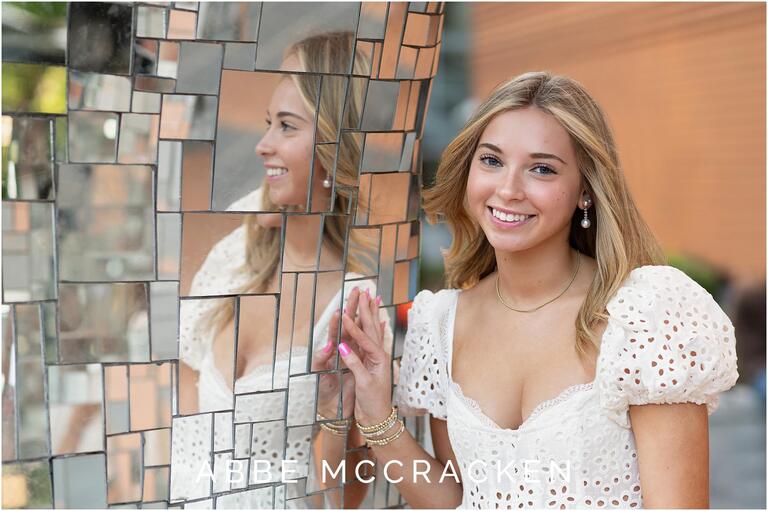 Senior portrait of a blonde girl leaning against the Fire Bird in Charlotte, NC