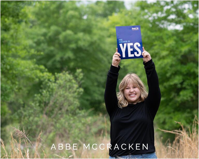 Senior spotlight image of blonde high school graduate sharing her admissions packet to Pace Musical Theater