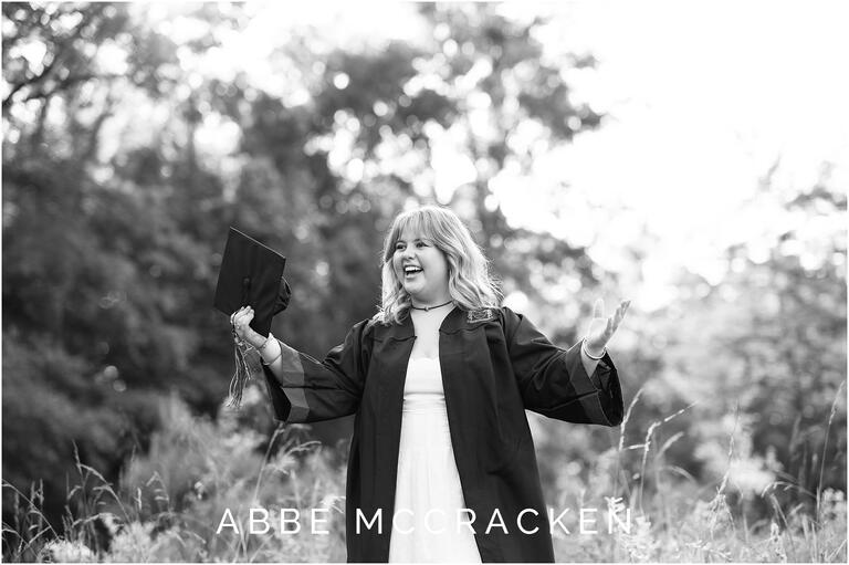 Candid graduation photo of a senior girl who is surprised that she caught her cap, senior portraits in Charlotte NC